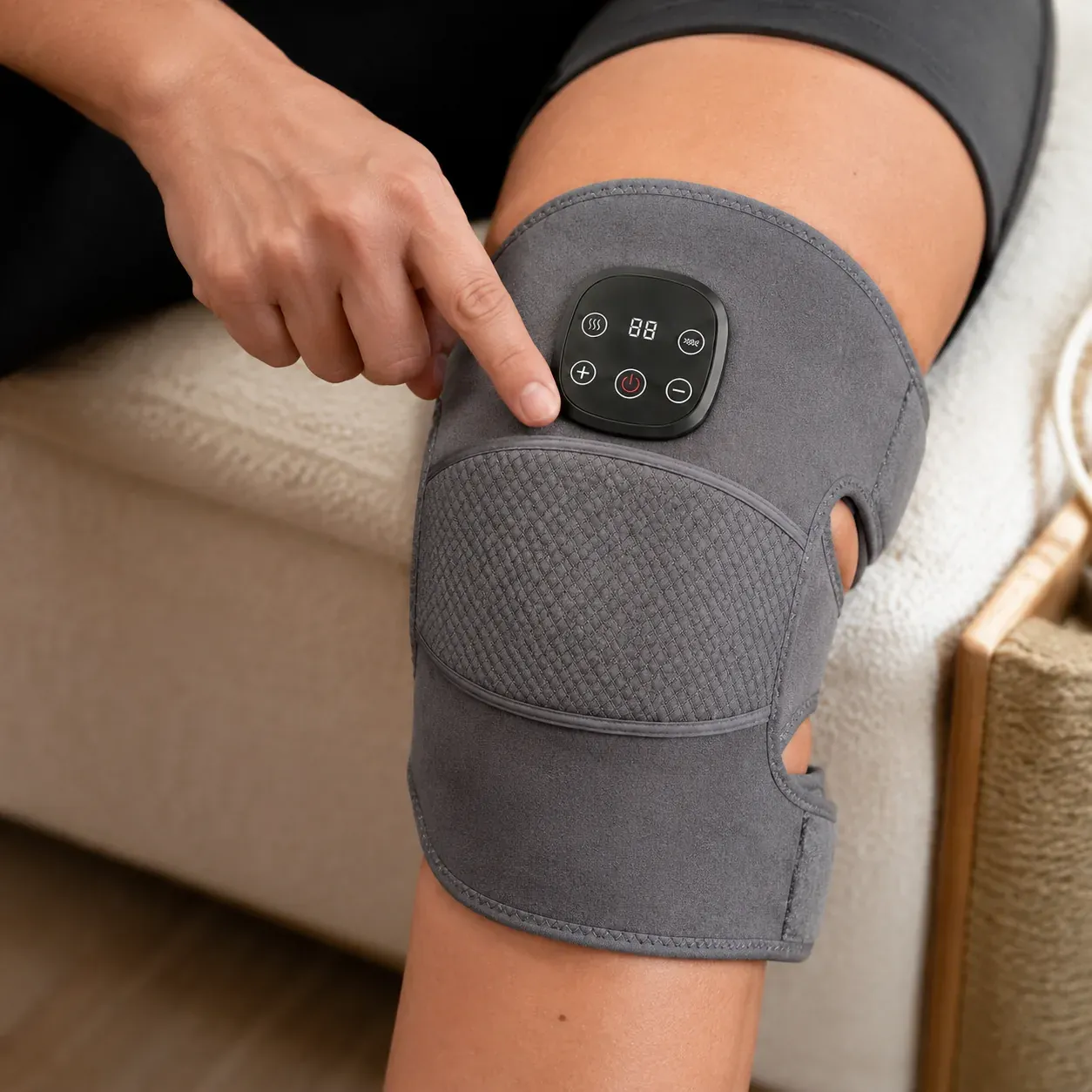 A finger selecting heat and vibration on the ReliefMD Knee Massager control panel